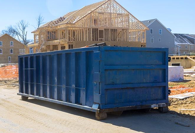 a garbage truck emptying a full residential dumpster into its rear compartment